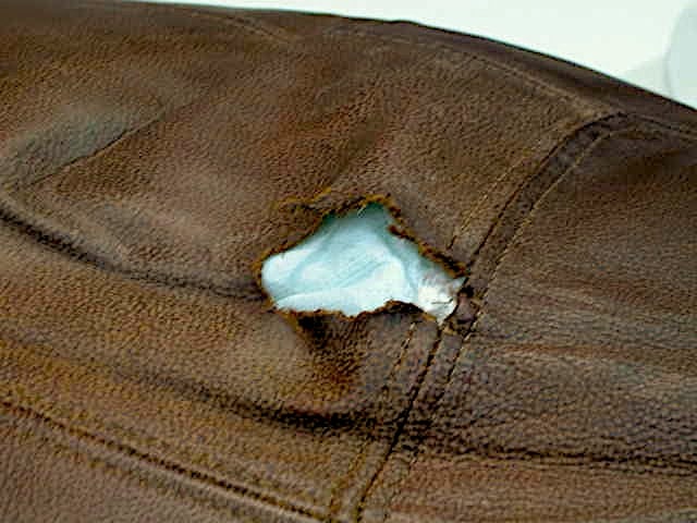 Massive Hole in Leather Cushion